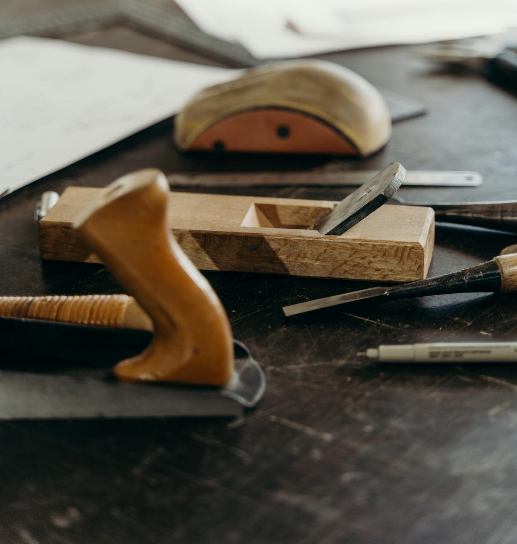 Close-up of woodworking tools on a craftsman's workbench, highlighting creativity and carpentry.
