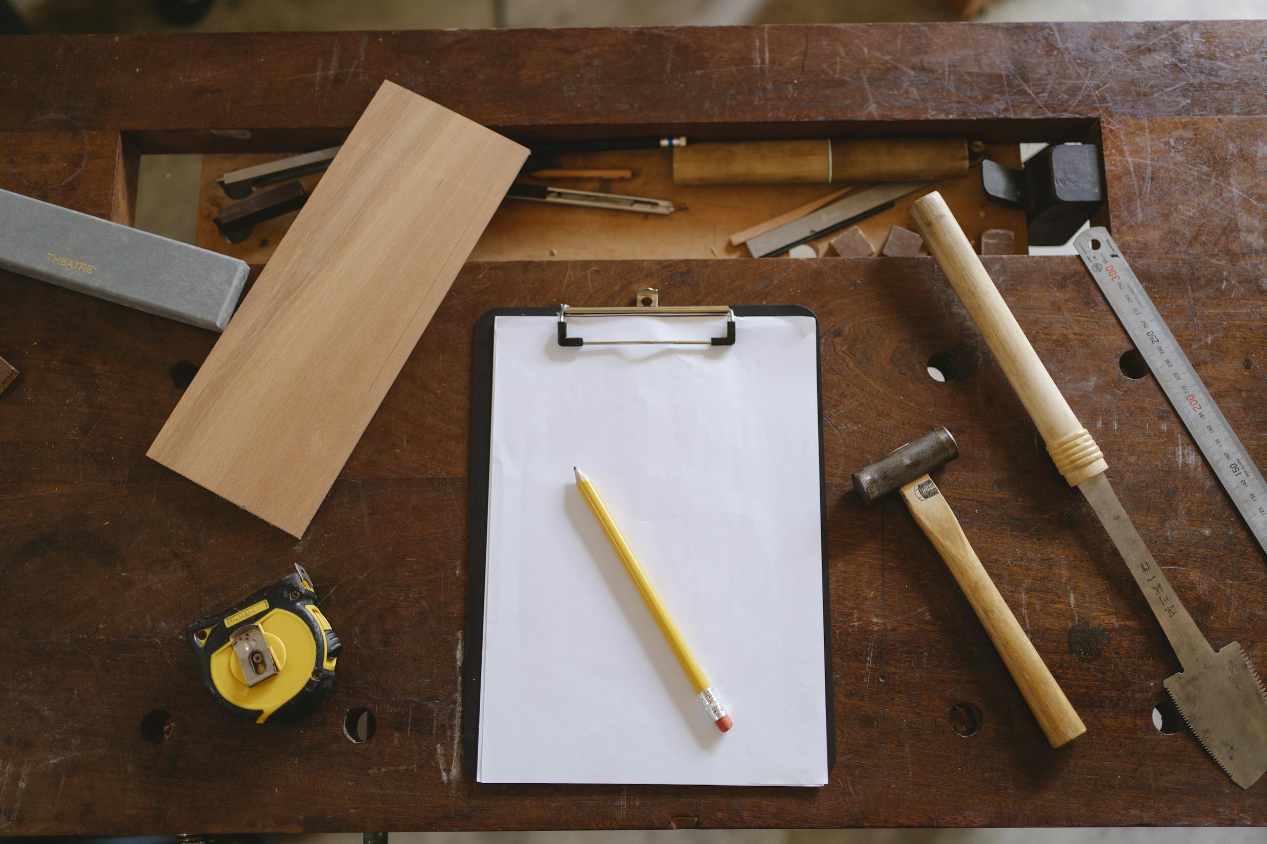 Flatlay of carpentry tools on a wooden workbench, showcasing craftsmanship essentials.