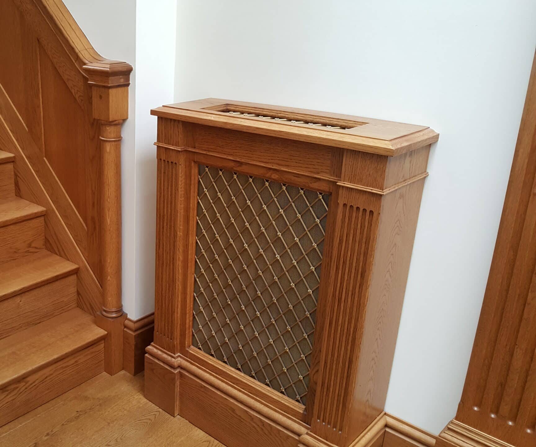 Radiator Cover with wall panelling and wooden staircase.